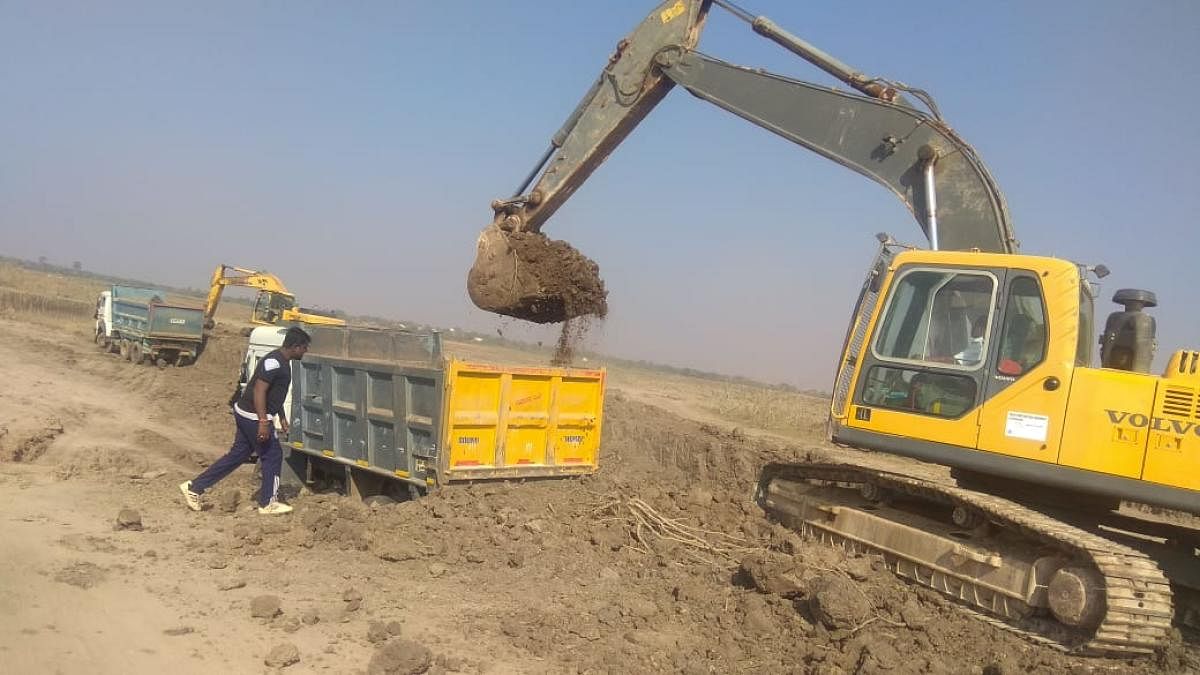 Progressing Revival work is underway at the Nidashesi lake near Kushtagi town in Koppal; villagers gathered at the project inauguration ceremony; a view of the parched lake; earth-moving machines in the desilting process.
