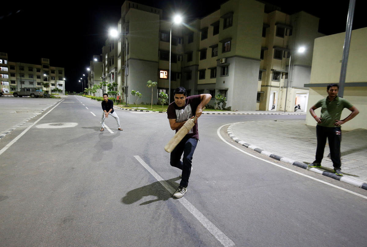 Residents play cricket under street lights at the Gujarat International Finance Tec-City (GIFT) at Gandhinagar, in the western state of Gujarat, India, March 27, 2019. REUTERS/Amit Dave