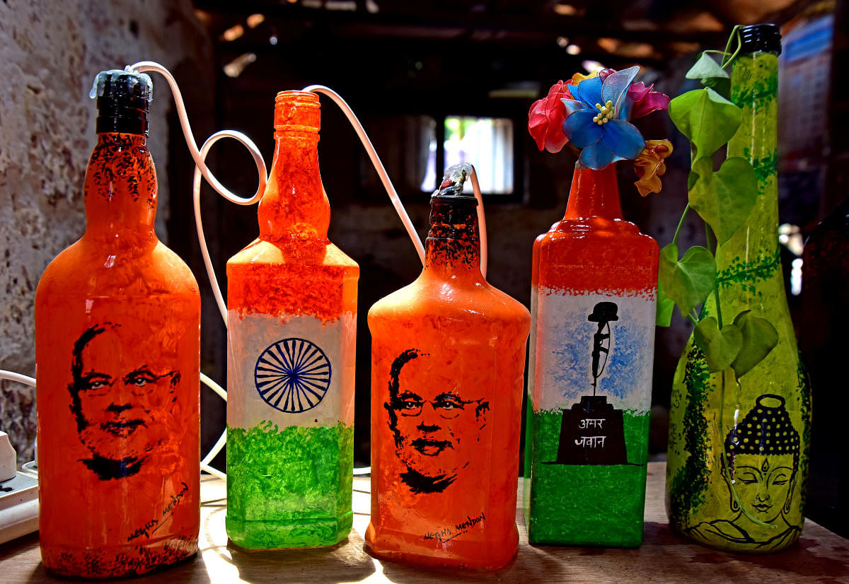 Elegant Open air Bottle Art exhibition-cum-sale organised at Mendon's backyard on the banks of Palguni river in Bokkapatna; bottles with pictures of Abhinandan and Narendra Modi. Photos by Govindraj Javali
