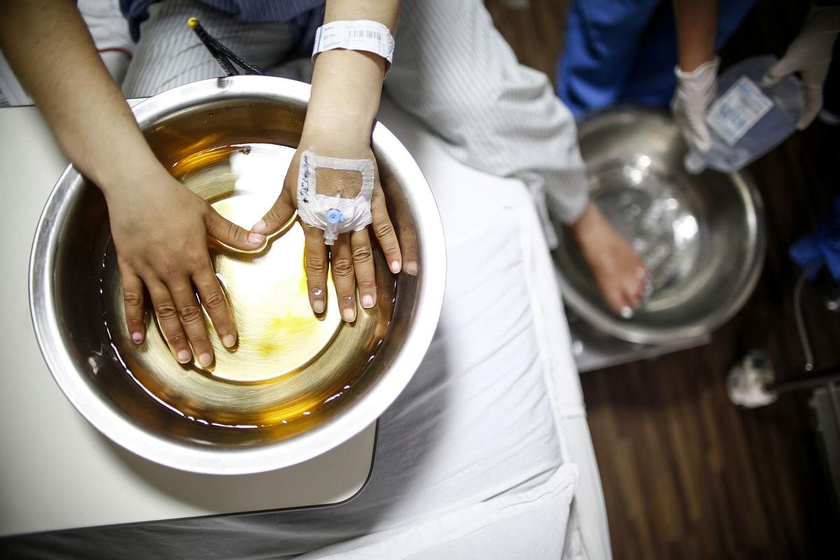 Indian Everest climber Ameesha Chauhan dips her fingers in a warm solution at a hospital in Kathmandu on May 27, 2019.