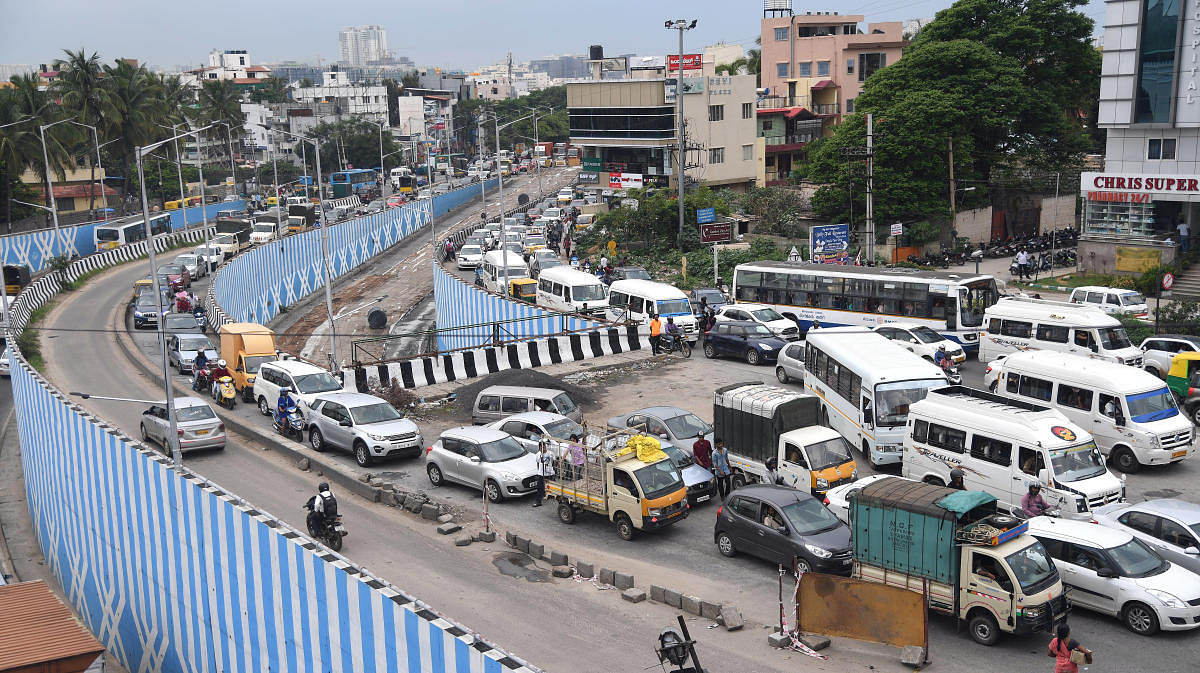 Traffic crawls on either side of the flyover at Hennur junction due to white-topping work on the road leading to KR Puram. DH Photo/Srikanta Sharma R