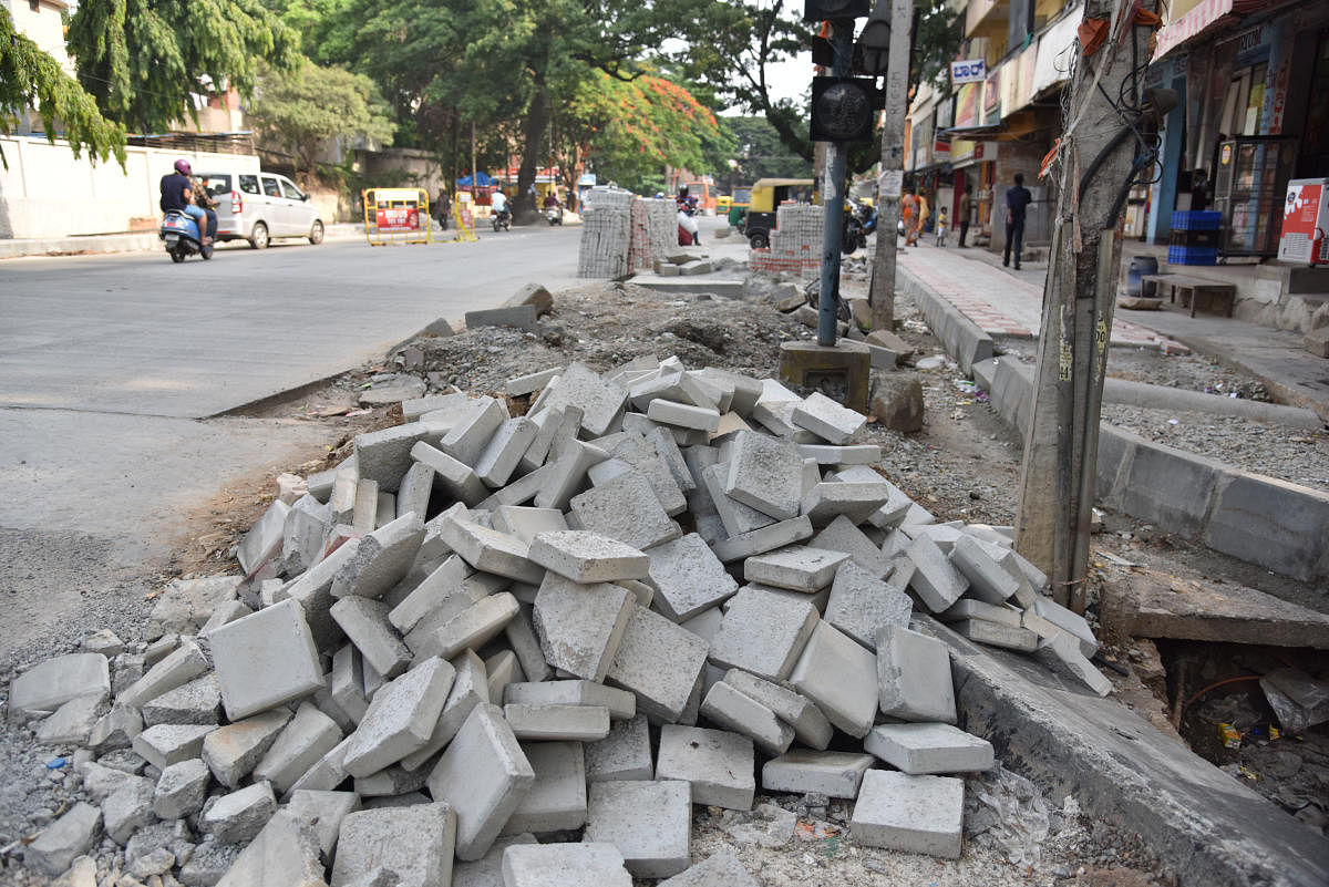 Ongoing white-topping work near Banashankari poses problems for pedestrians on Saturday. DH Photo/Janardhan B K