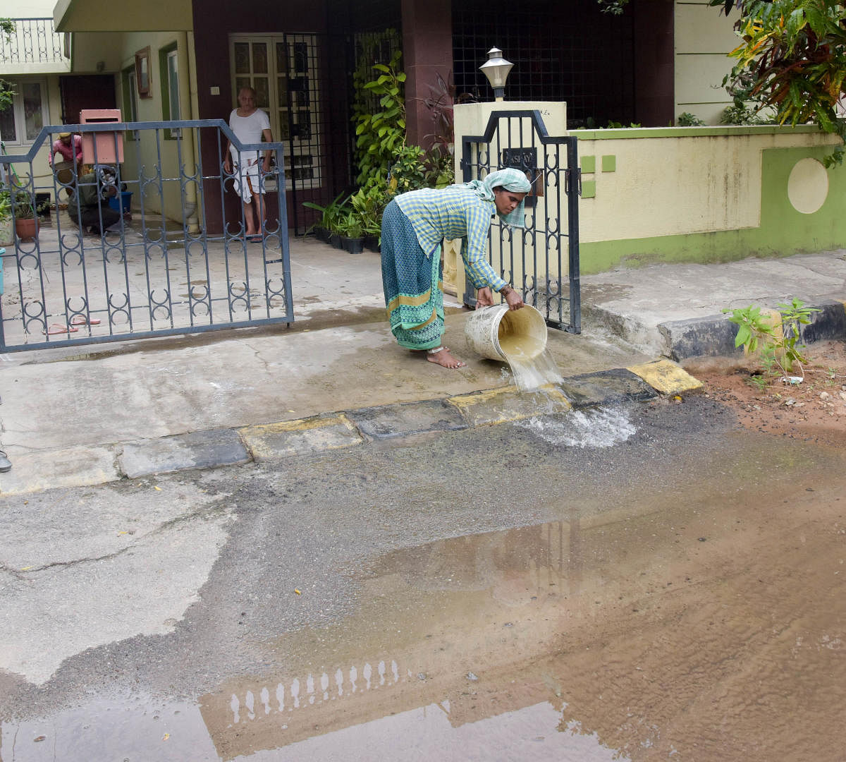 A worker emptying the contaminated water on to the streets. DH Photo/BH Shivakumar
