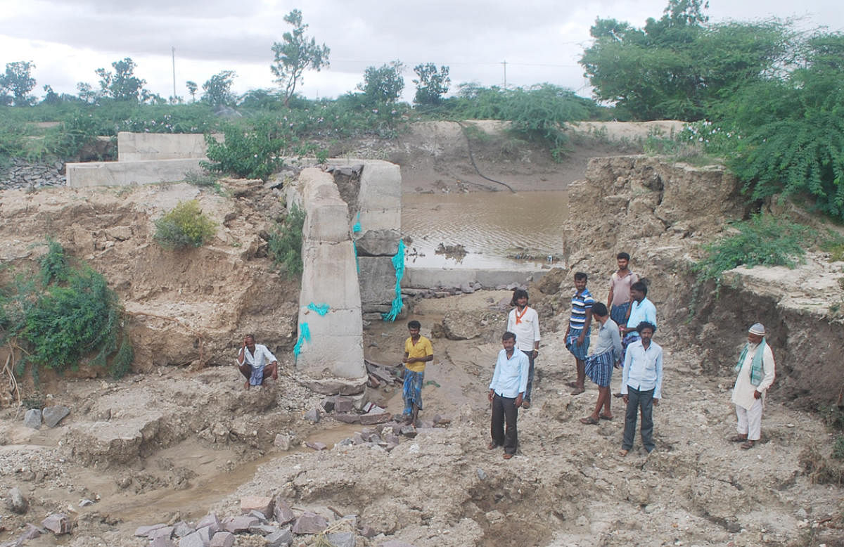 A check dam breached at Putagaumbadni village in Lakshmeshwar taluk of Gadag district following heavy rainfall that lashed the region last week. DH Photo
