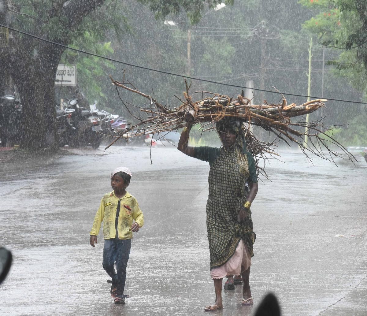 A woman and her son caught in the rain in Dharwad on Monday. dh photos