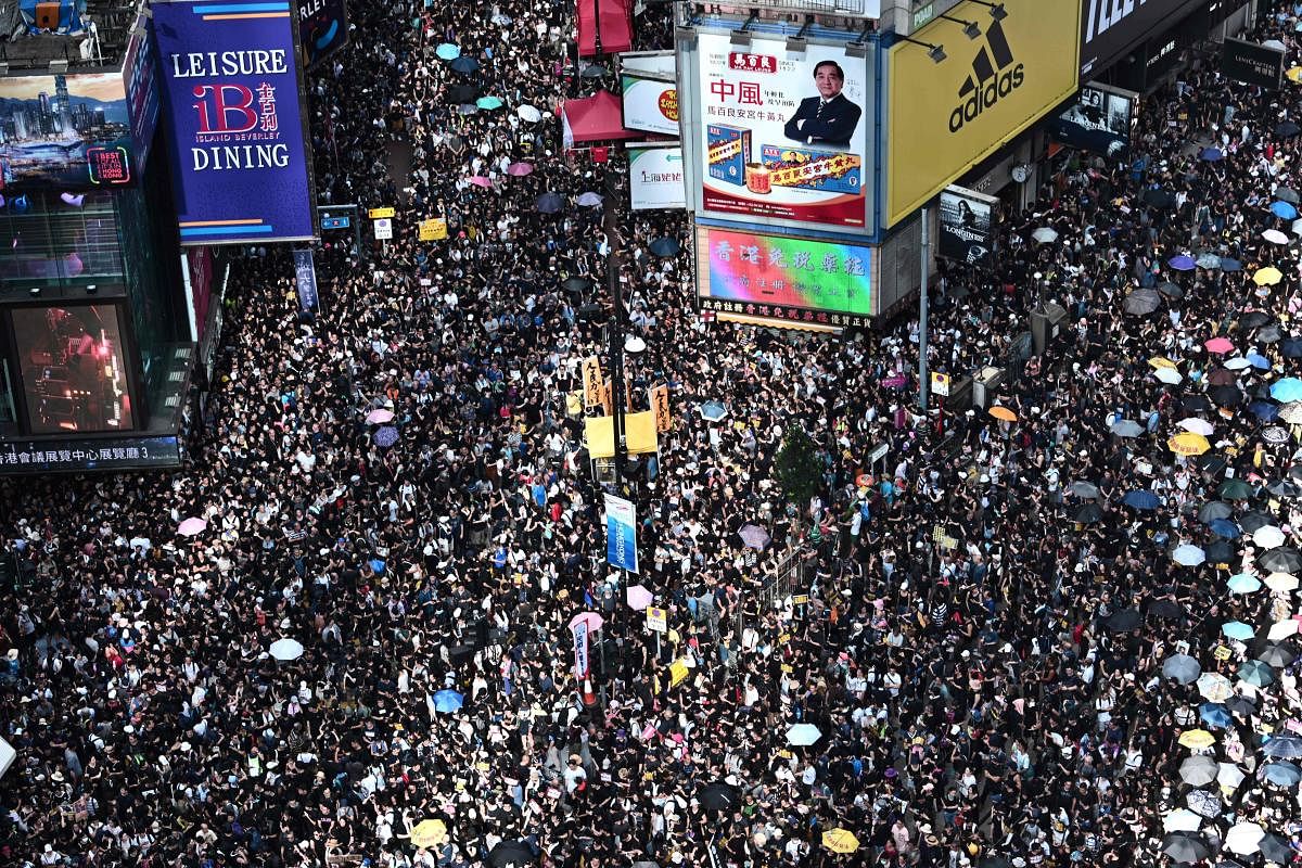Protesters march against a controversial extradition bill in Hong Kong on July 21, 2019. (Photo by AFP)