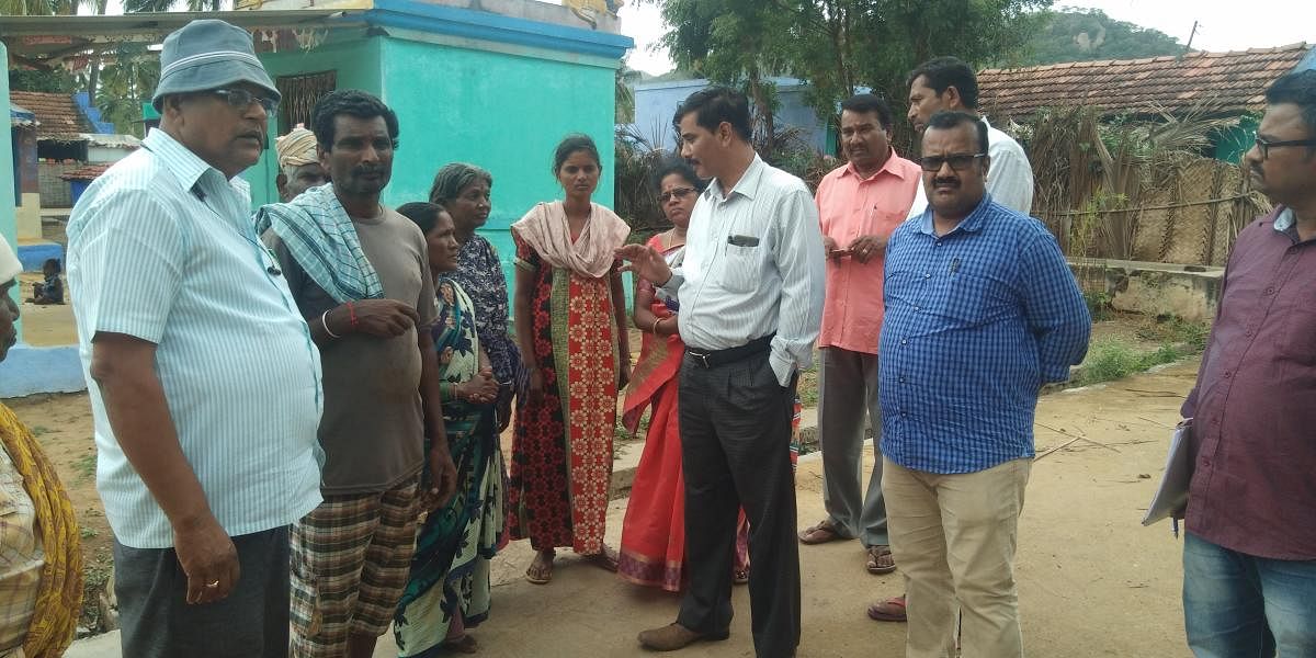 Officials of the Social Welfare department and Police personnel collect details on untouchability practises in Hoogyam village, Hanur taluk, on Tuesday.
