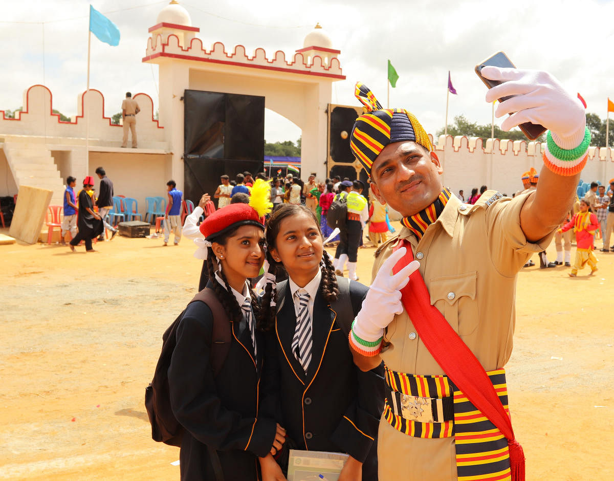 A policeman poses with school girls during the Independence Day parade at Field Marshal Manekshaw Parade grounds in Bengaluru on August 15, 2019.