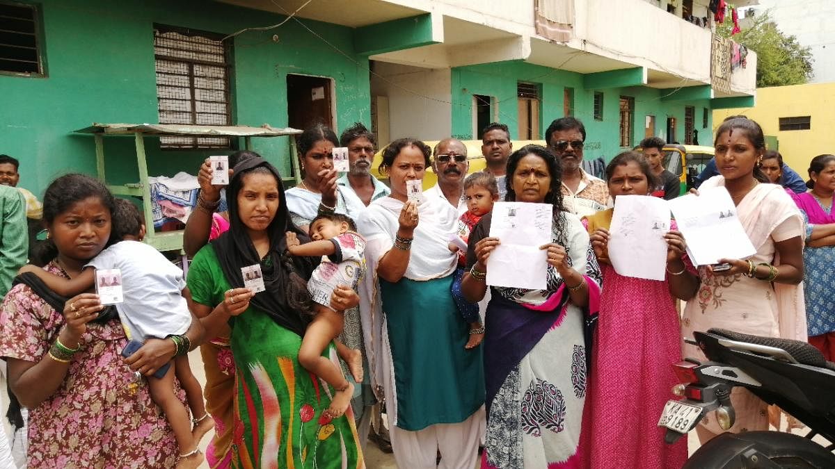 Residents of Dr BR Ambedkar Nagar display the biometric cards issued by the Karnataka Slum Development Board; (right) the community hall and government school that came up in place of the shacks. DH PHOTOS/SANDESH MS 