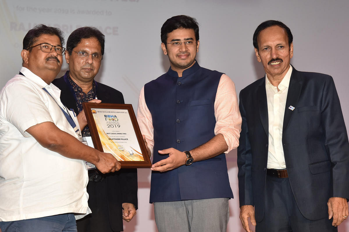 Bangalore South parliamentarian L S Tejasvi Surya presents the 'Best Food' award to a restaurant owner at an awards ceremony hosted by the Bruhat Bangalore Hotel Association (BBHA) on Saturday. BBHA Chairman P C Road is present. DH PHOTO/MANJUNATH M S