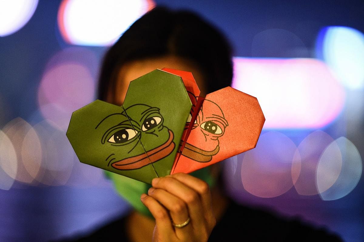 A protester holding origami hearts with a depiction of Pepe the Frog, a character used by pro-democracy activists as a symbol of their struggle, by the waterfront along Victoria Harbour in Hong Kong's Tim Sha Tsui district. (Photo by AFP)