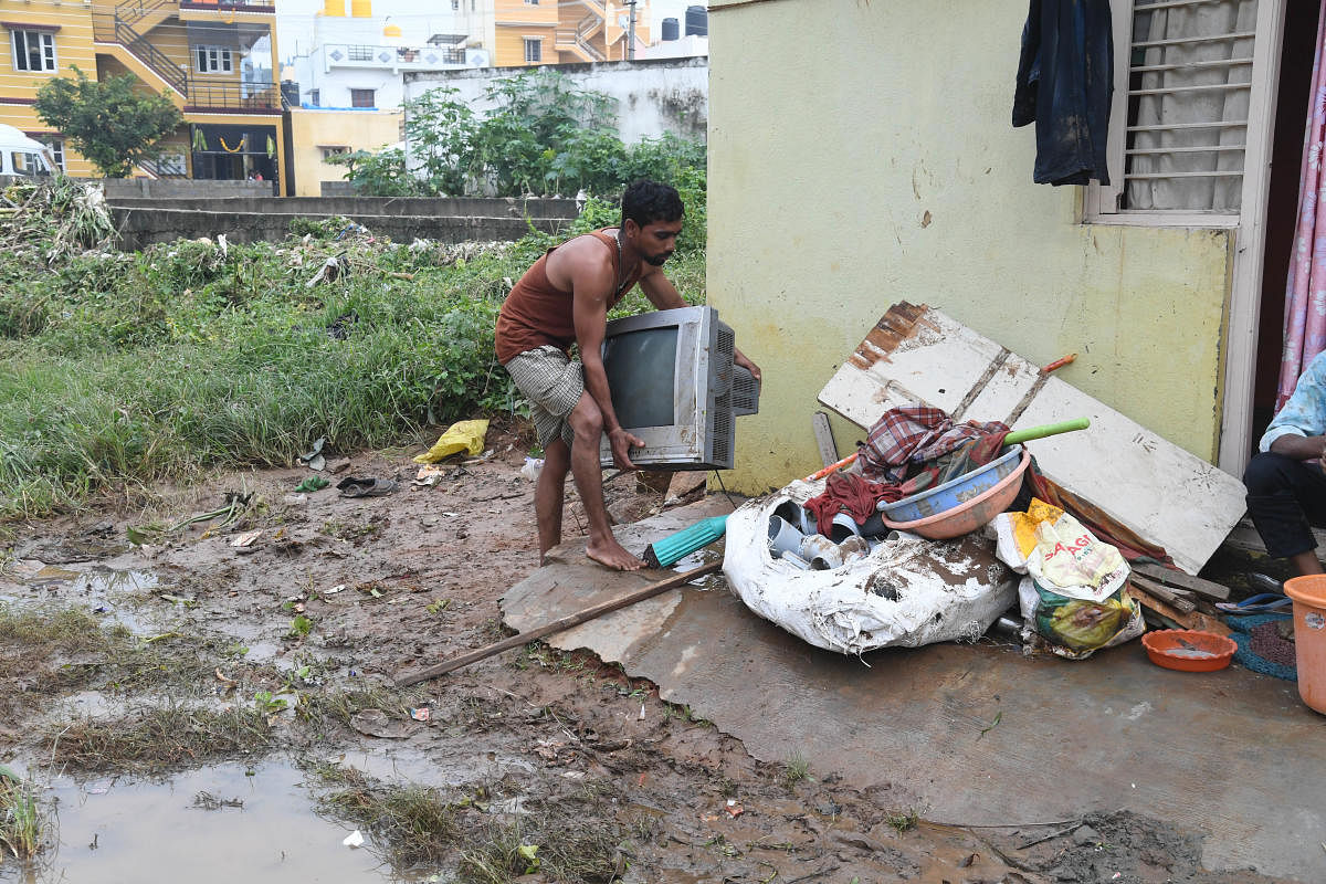 A man tries to salvage his belongings following the flash floods. DH PHOTO/B H SHIVAKUMAR