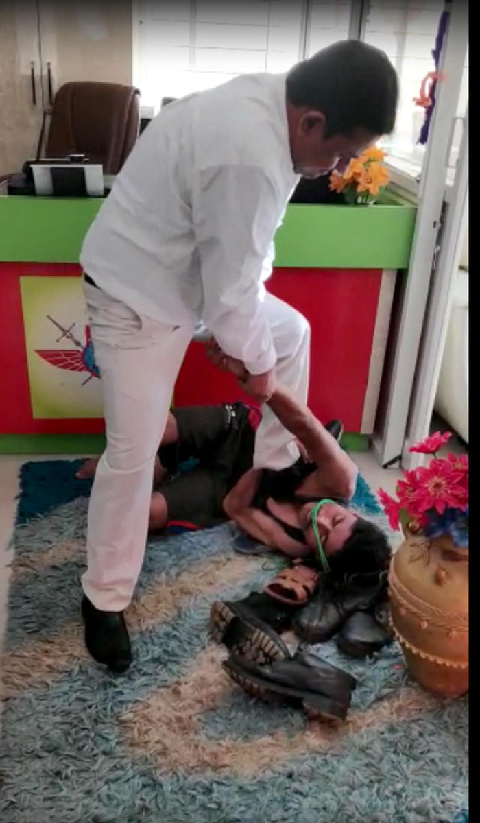 A video grab shows Salim Khan, the owner of Bangalore Security Force, kicking two of his employees.