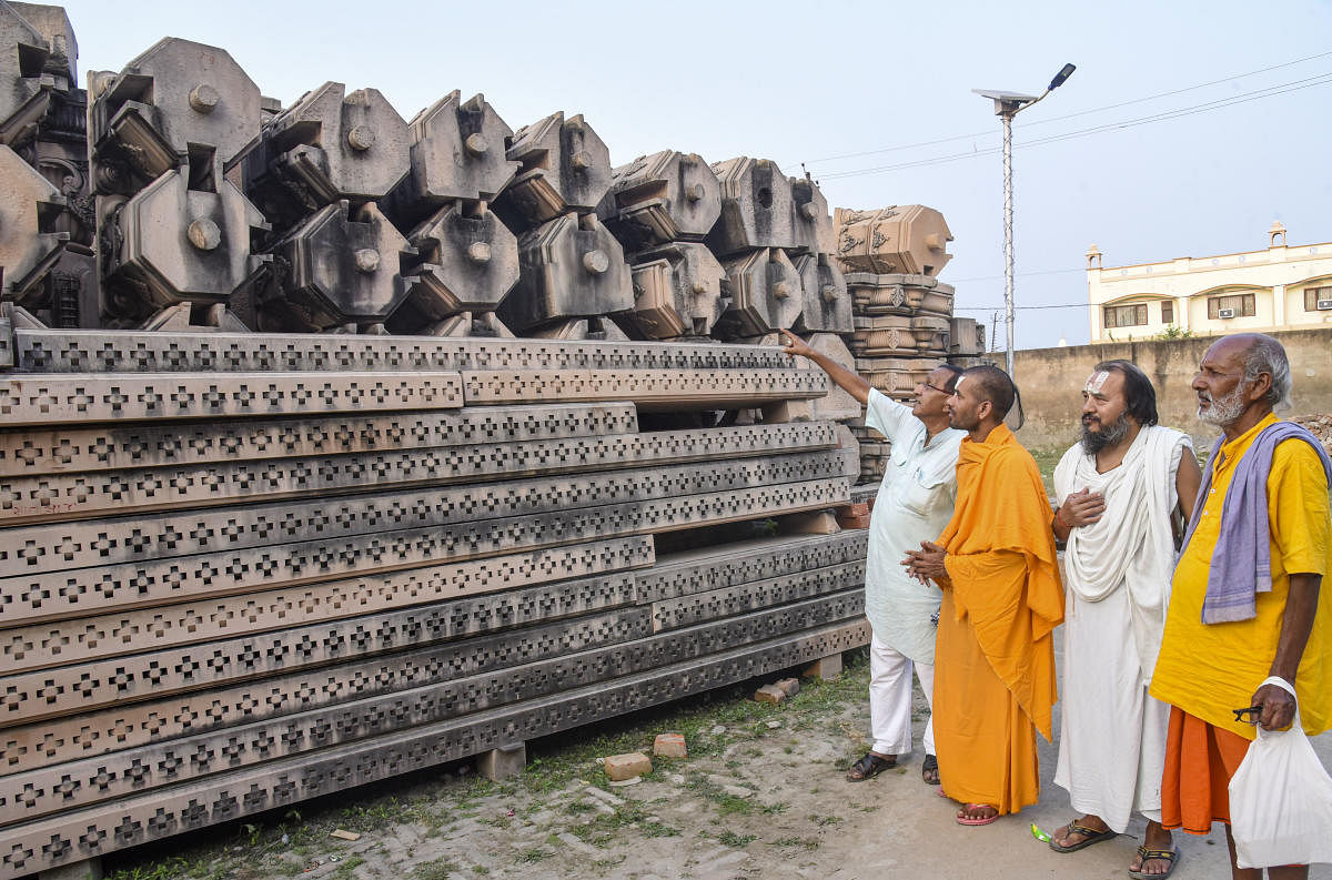 Ayodhya: Sadhus look at stone slabs, carved-out for the construction of Ram Temple, at Shri Ram Janmbhoomi Karyashala (workshop) in Karsewakpuram, Ayodhya. Credit: PTI File Photo