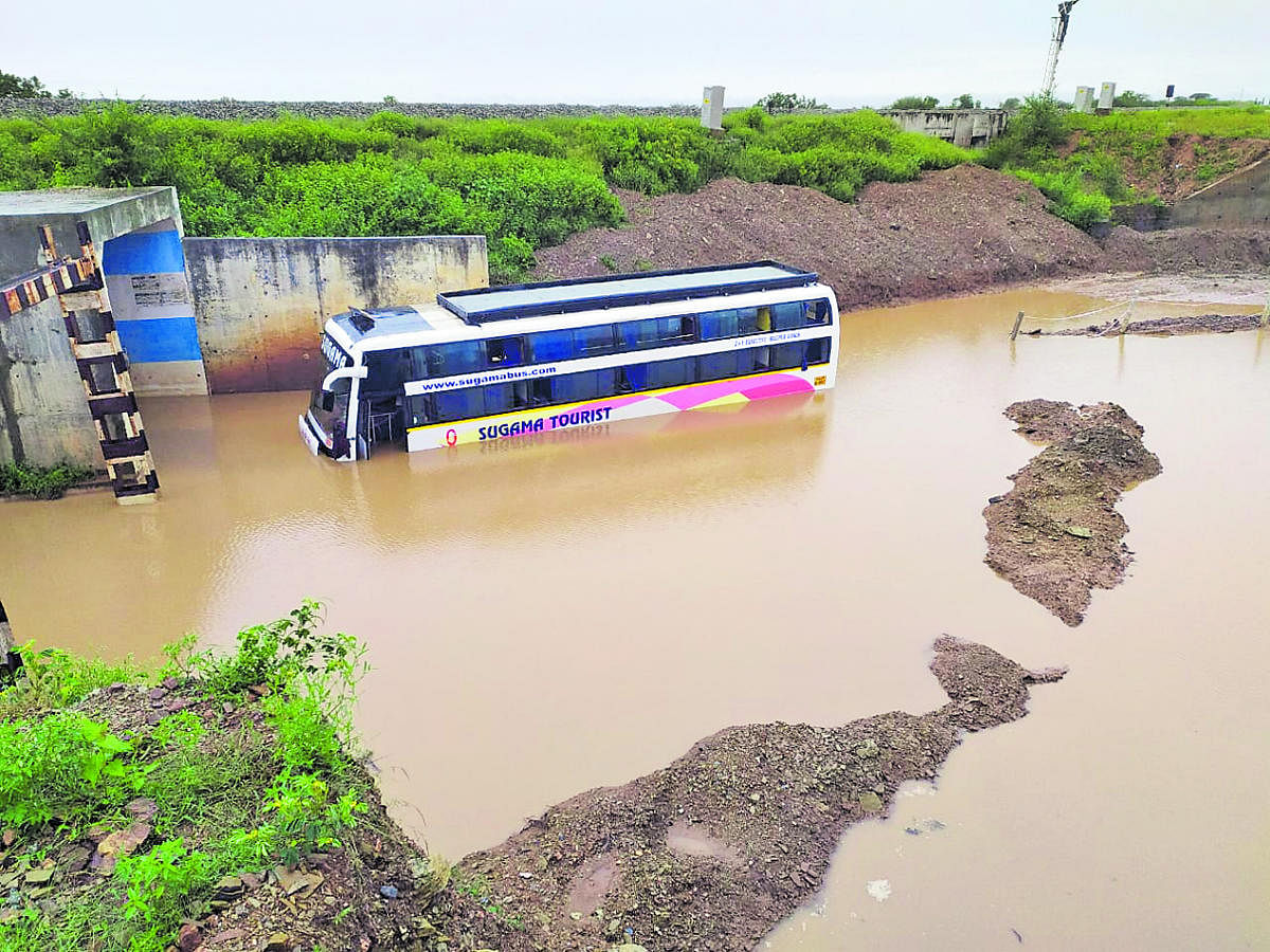 A private bus trapped in a flooded railway underpass near Savanur in Haveri taluk.