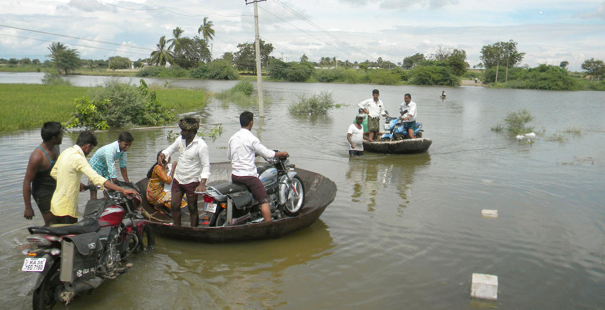 People use coracles to reach Itigi village in Ballari taluk following after the connecting Narihalla bridge submerged.