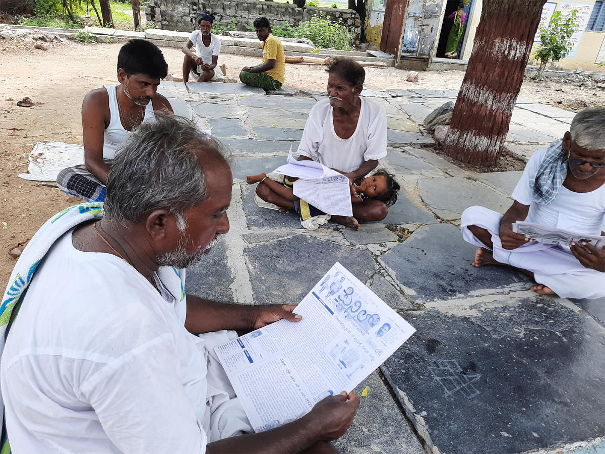 Villagers engrossed in reading the 'Pencil'