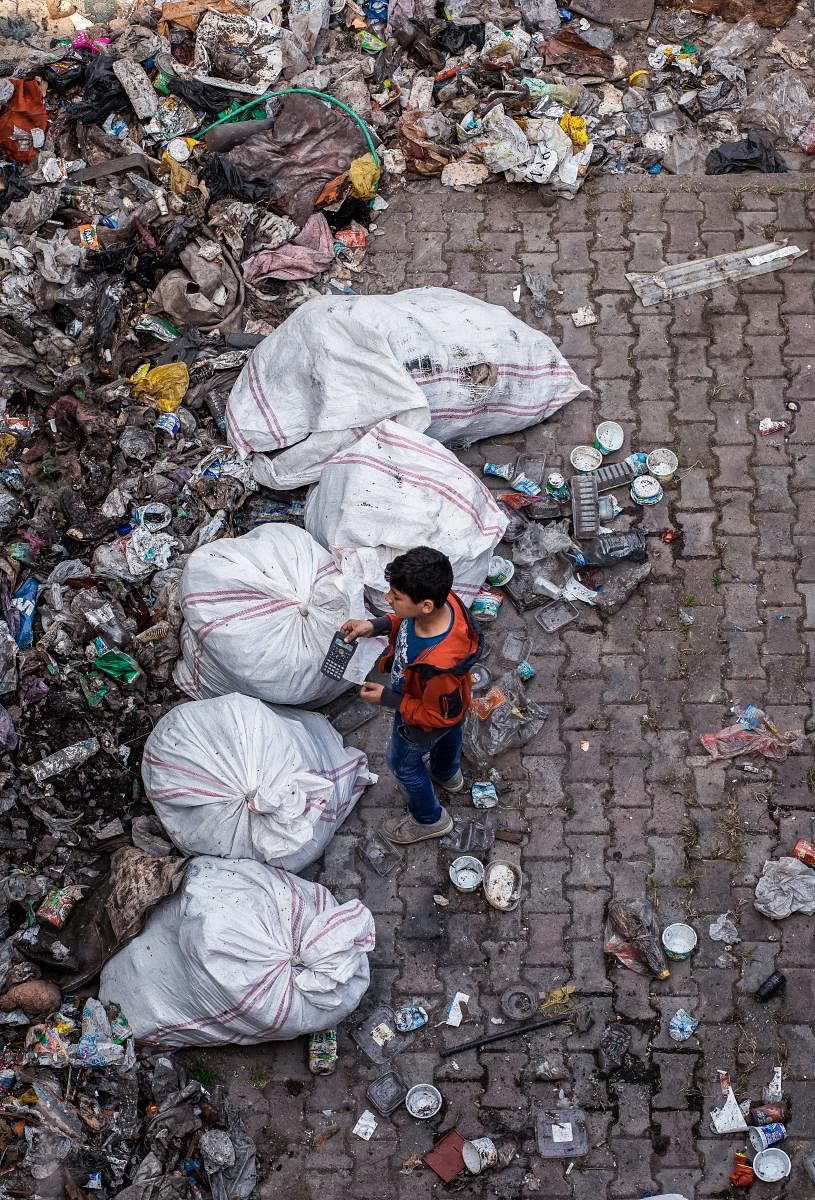 Child standing near garbage
