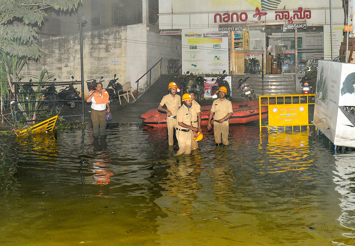 Rescue workers on a flooded street near Hulimavu on Sunday. SPECIAL ARRANGEMENT