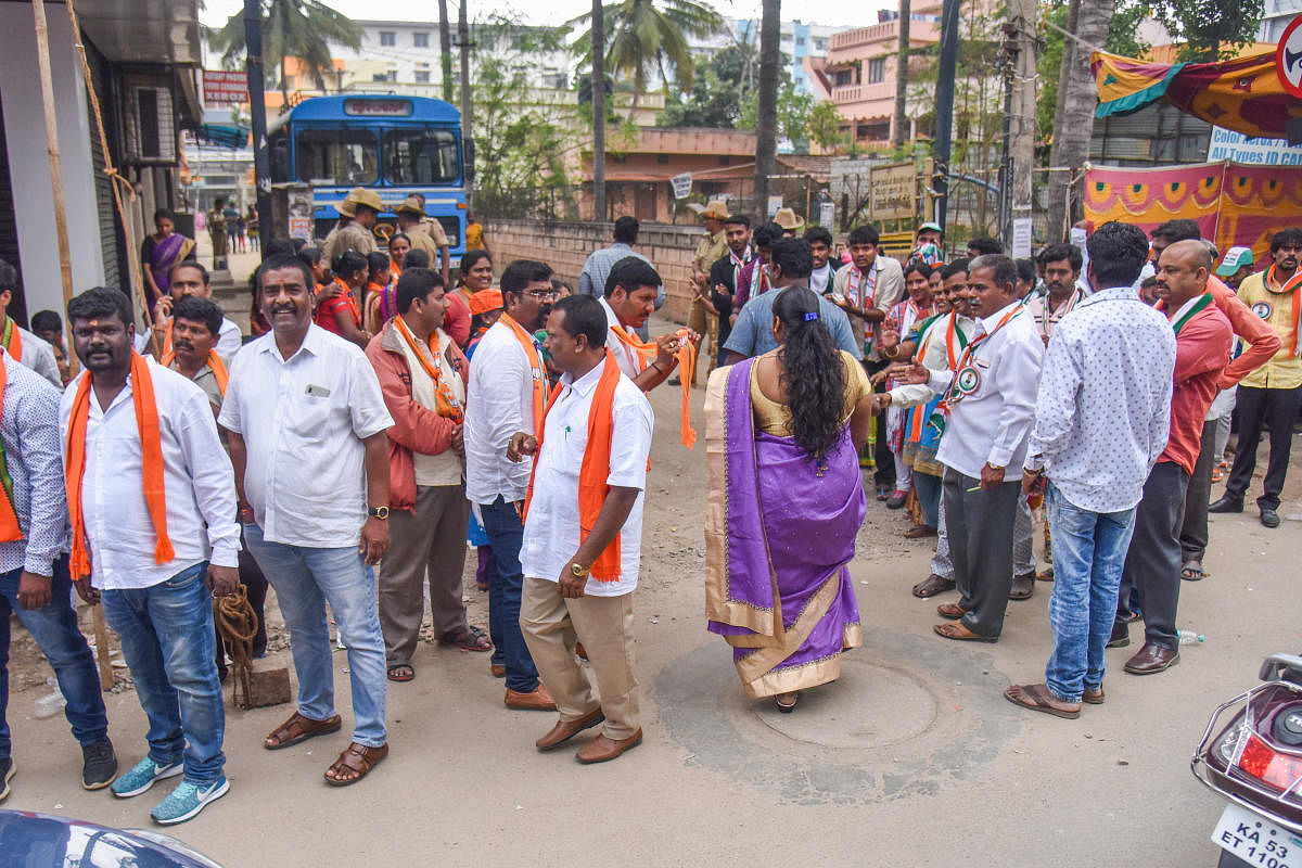 Party workers try to woo voters at a booth in Ramamurthy Nagar. Dh PhotoS/S K Dinesh