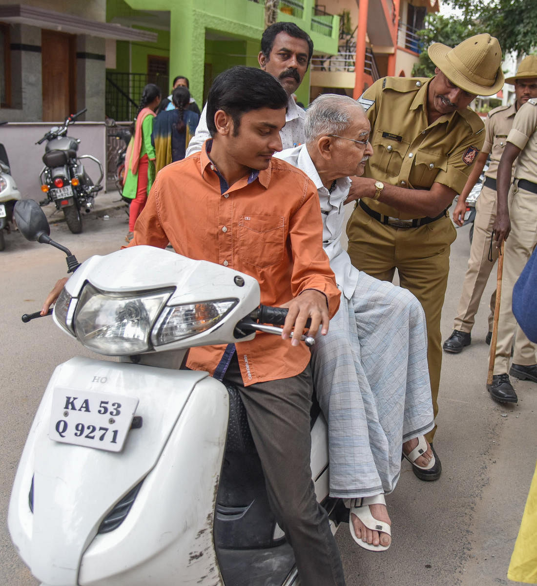 Police help a senior citizen to a polling booth at KR Puram.