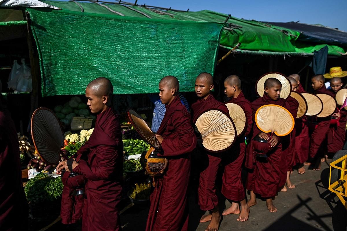 Buddhist monks collecting alms at a market in Mawgyun of Irrawaddy region. (Photo by AFP)