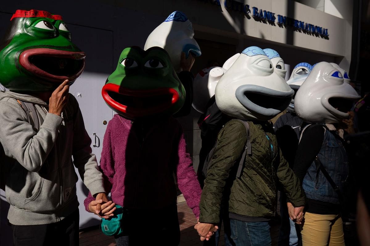 People wearing masks depicting Pepe the Frog, a character used by pro-democracy activists as a symbol of their struggle, gather before the 'Human Rights Day' rally from Victoria Park to Chater Road in Hong Kong on December 8, 2019. (Photo by AFP)