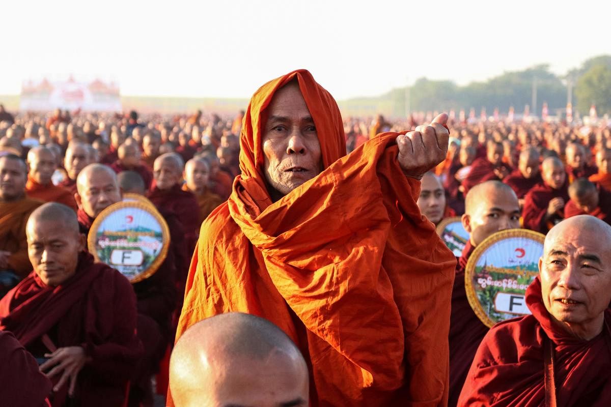 Monks line up for alms during the alms-giving ceremony to 30,000 monks organize by the region government of Mandalay affiliated with Dhammakaya Foundation at Chanmyathazi Airport in Mandalay. (Photo by AFP)