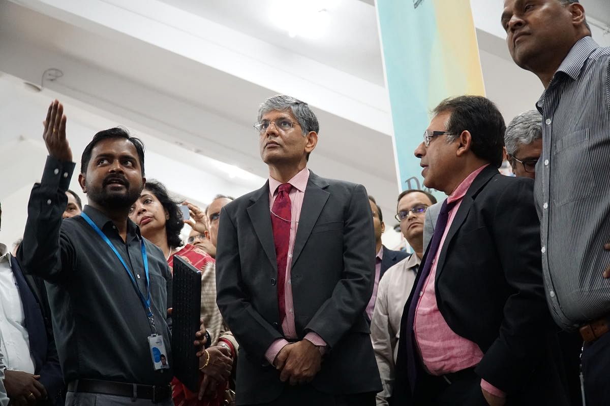 Dr A R Sihag (centre), Secretary of the DHI, who inaugurated CECF facility at IISc on Dec 13, 2019, looks at screen showing how smart factories operate. DH PHOTO/AKHIL KADIDAL