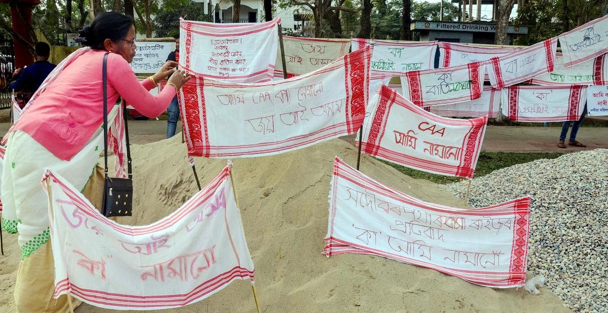 Dibrugarh: A protestor hangs Assamese traditional 'gamusas' with various messages as part of a demonstration against the Citizenship Amendment Act (CAA) in Dibrugarh, Saturday, Dec. 21, 2019. (PTI Photo)