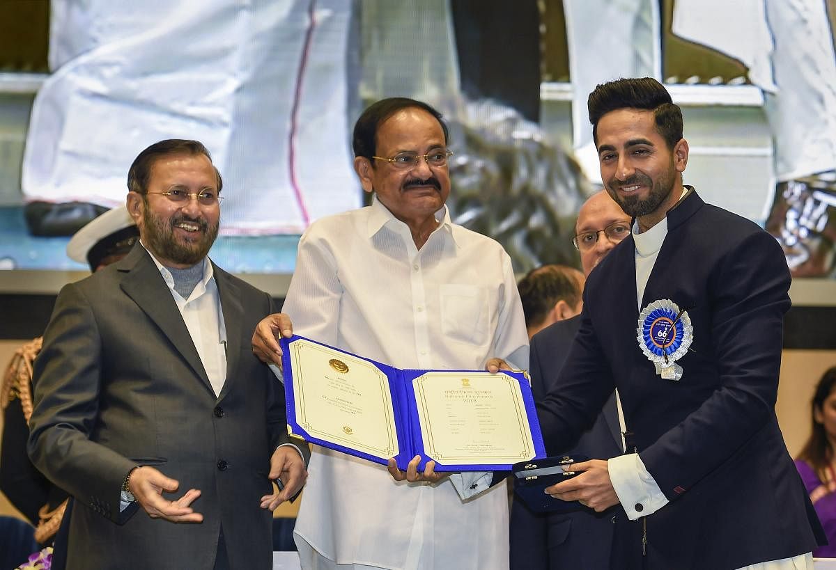 Vice President M Venkaiah Naidu presents the Best Actor (shared) award to actor Ayushmann Khurrana for his role in the film 'Andhadhun' during the 66th National Film Awards function at Vigyan Bhavan in New Delhi, Monday, Dec. 23, 2019. Union I&B Minister Prakash Javadekar is also seen. (PTI Photo)