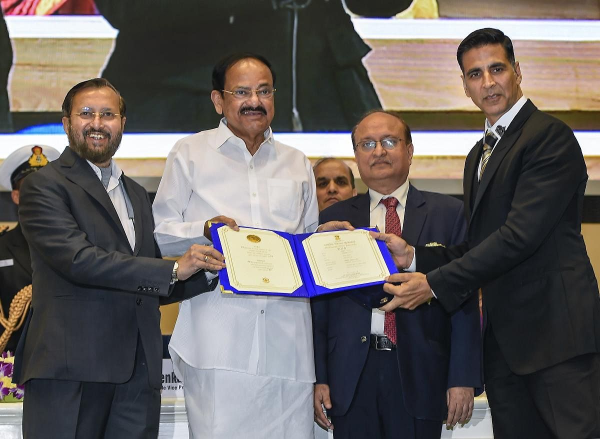 Vice President M Venkaiah Naidu presents the award for Best Film on Social Issues to 'Padman', being received by Actor Akshay Kumar, during the 66th National Film Awards function at Vigyan Bhavan in New Delhi, Monday, Dec. 23, 2019. Union I&B Minister Prakash Javadekar is also seen. (PTI Photo)