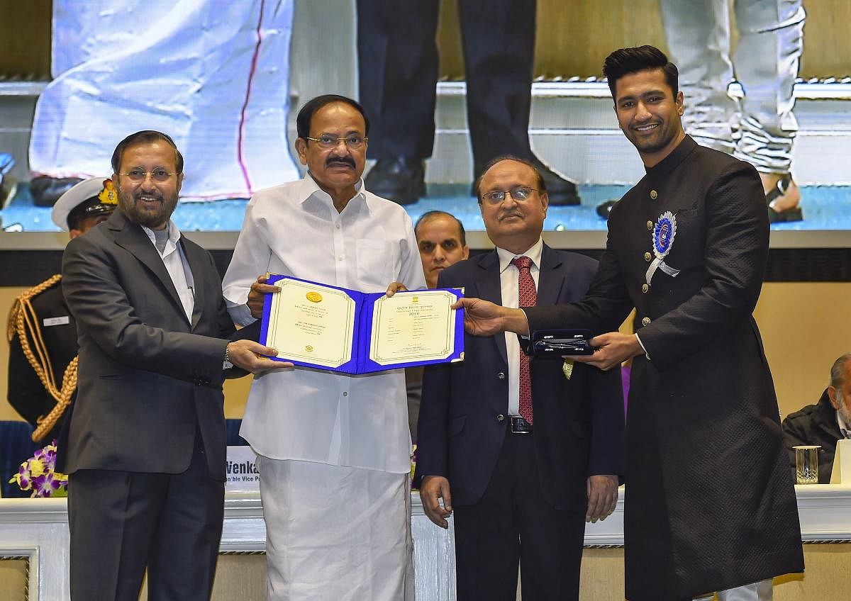 Vice President M Venkaiah Naidu presents the Best Actor award to actor Vicky Kaushal for his role in the film 'Uri: The Surgical Trike' during the 66th National Film Awards function at Vigyan Bhavan in New Delhi, Monday, Dec. 23, 2019. Union I&B Minister Prakash Javadekar is also seen. (PTI Photo)