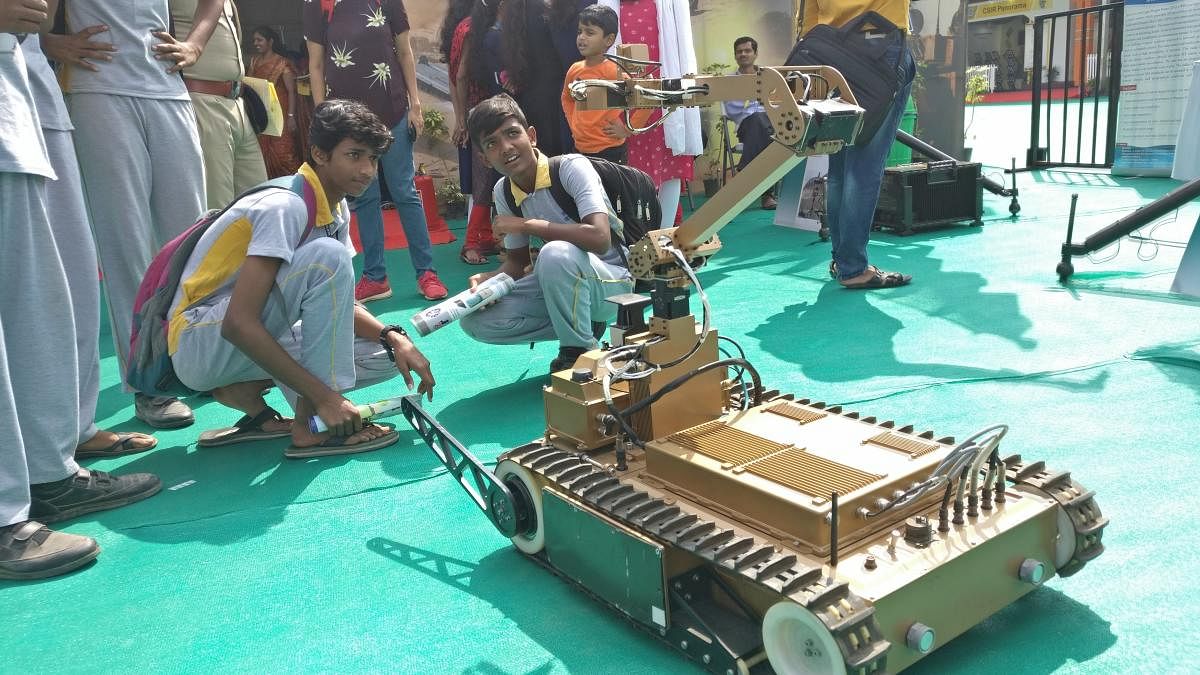 School students examine a Mini-UGV robot built by DRDO's CAIR lab.