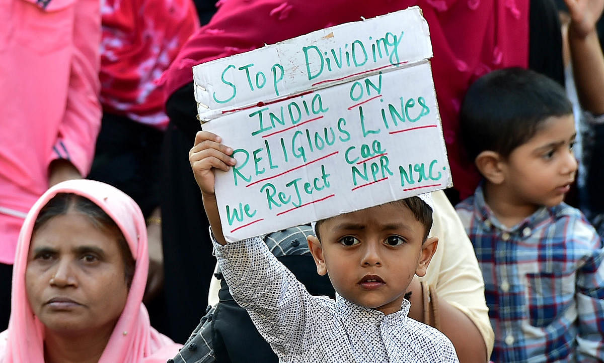 A boy holds a placard during the protest. DH PHOTO/RANJU P