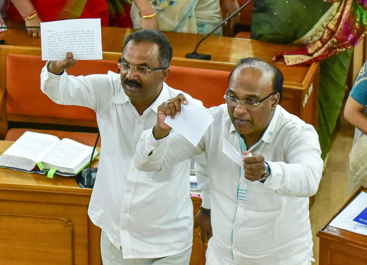 Opposition Congress members tear copies of the new draft of the BBMP ward delimitation plan. DH PHOTO/ IRSHAD MAHAMMAD