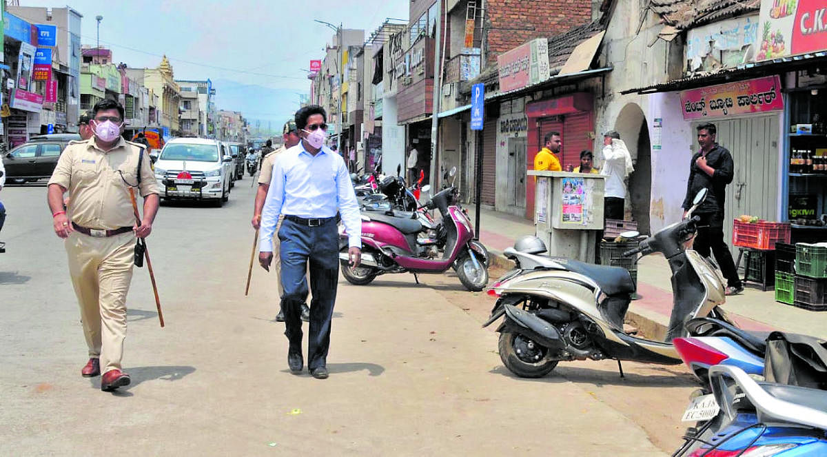 Deputy Commissioner Dr Bagadi Gautham and SP Harish Pande inspect the closure of shops on MG Road in Chikkamagaluru.