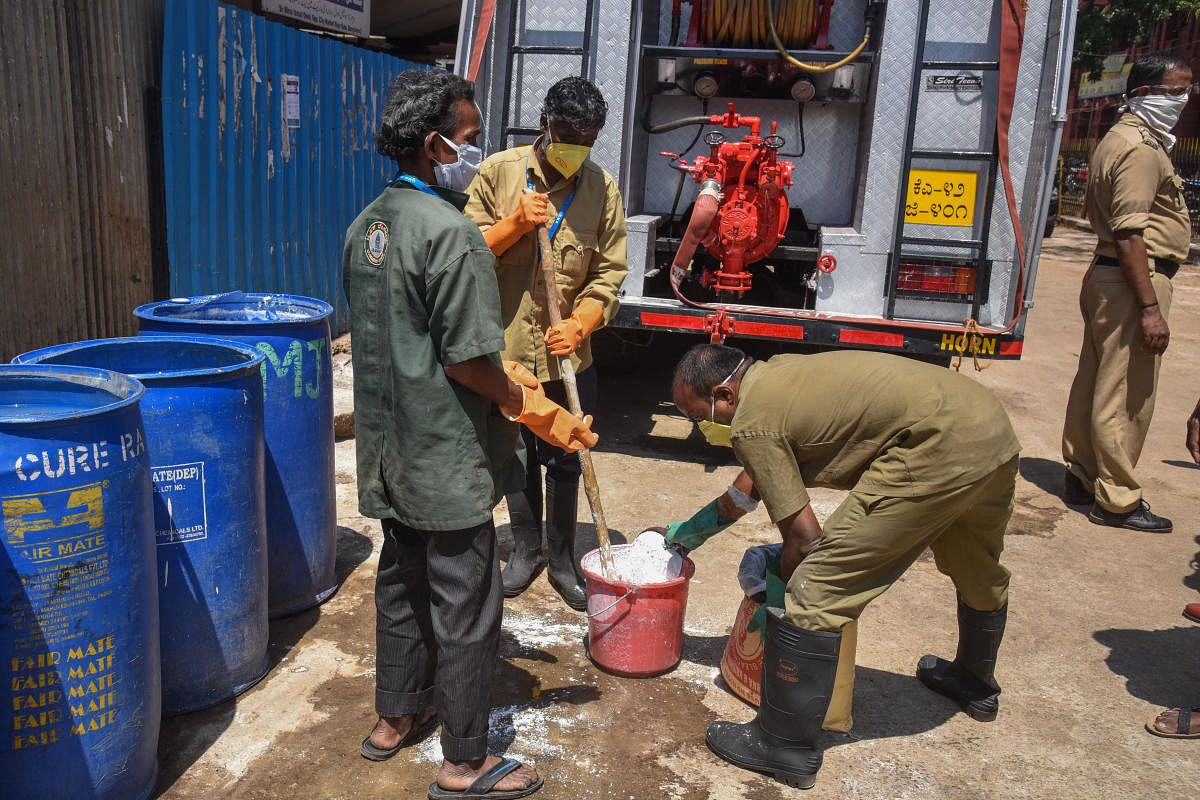 For Dh Akhil story: BBMP workers mixing Sodium Hydrochloride solution for spray in K R Market due to Caronavirus, Covid-19 lockdown in Bengaluru on Thursday. Photo by S K Dinesh
