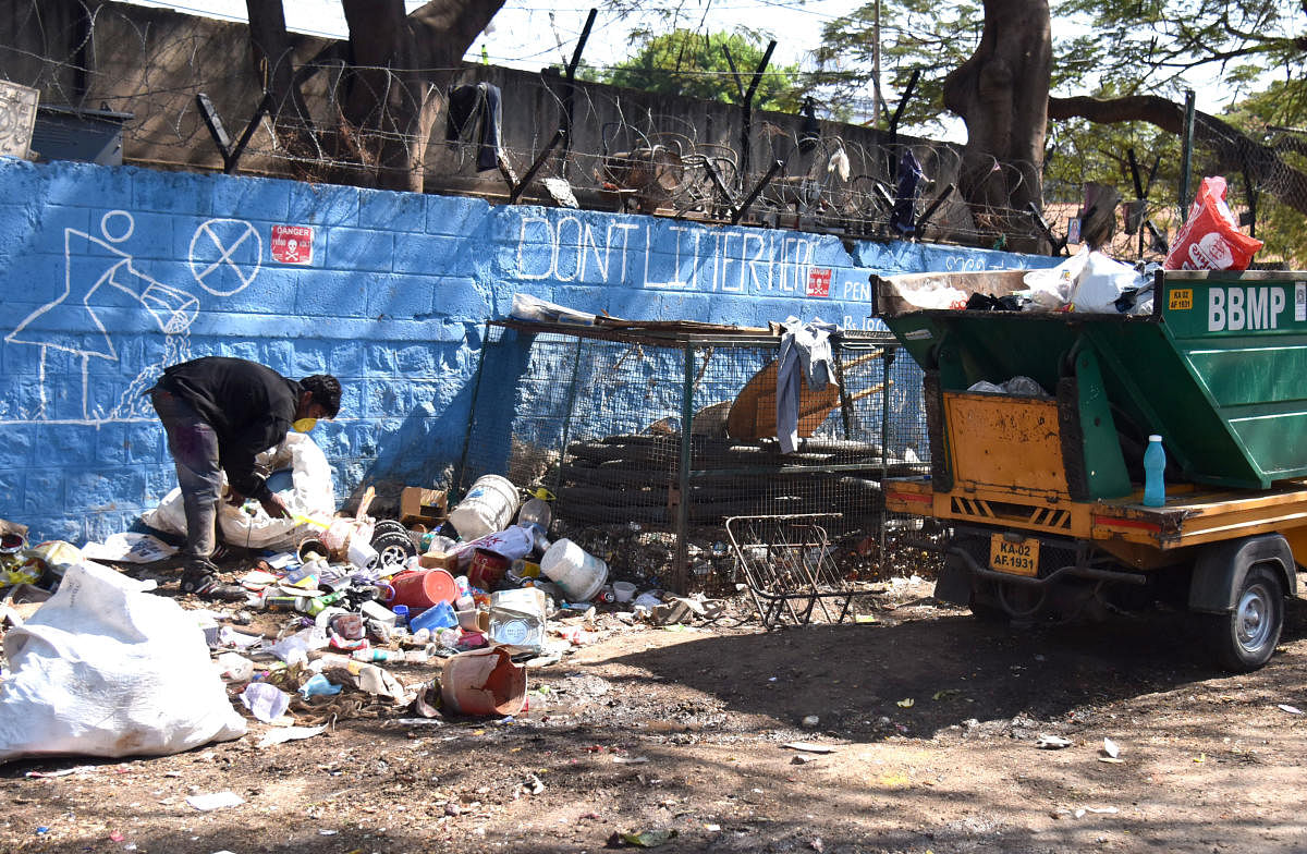 This pourakarmika, rummaging through garbage near the Adugodi junction, uses bare hands and no mask.