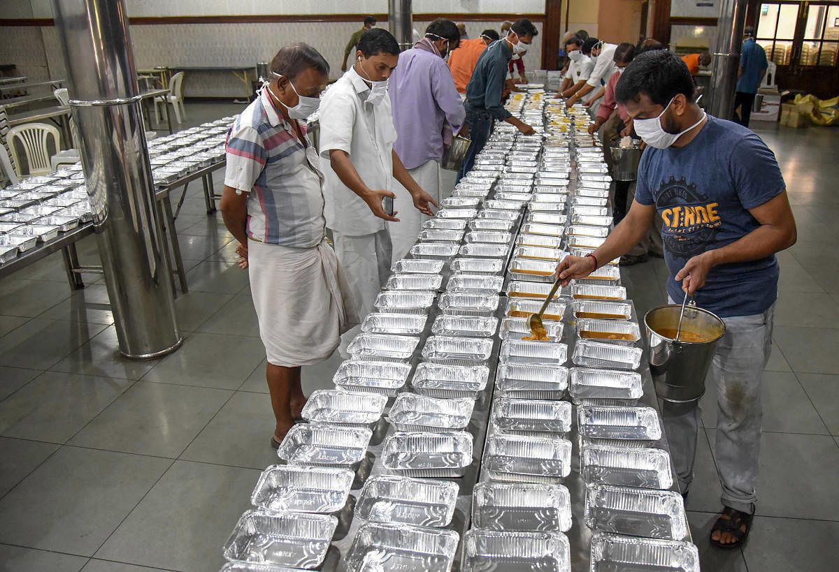 Workers prepare packaged food to be distributed among the poor, during a nationwide lockdown in the wake of coronavirus pandemic, at Ernakulam Karayogam in Kochi. (PTI Photo)