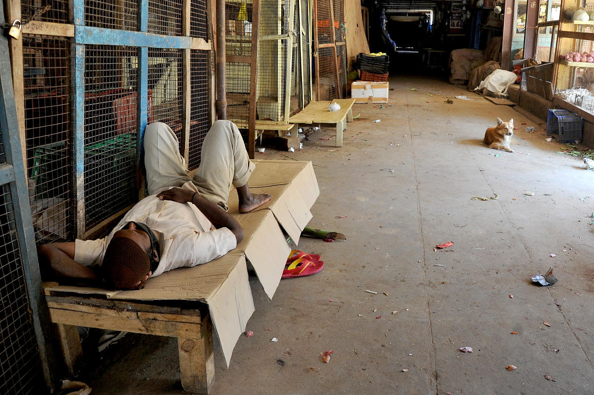 A man sleeps inside the closed Russell Market. DH PHOTO/PUSHKAR V
