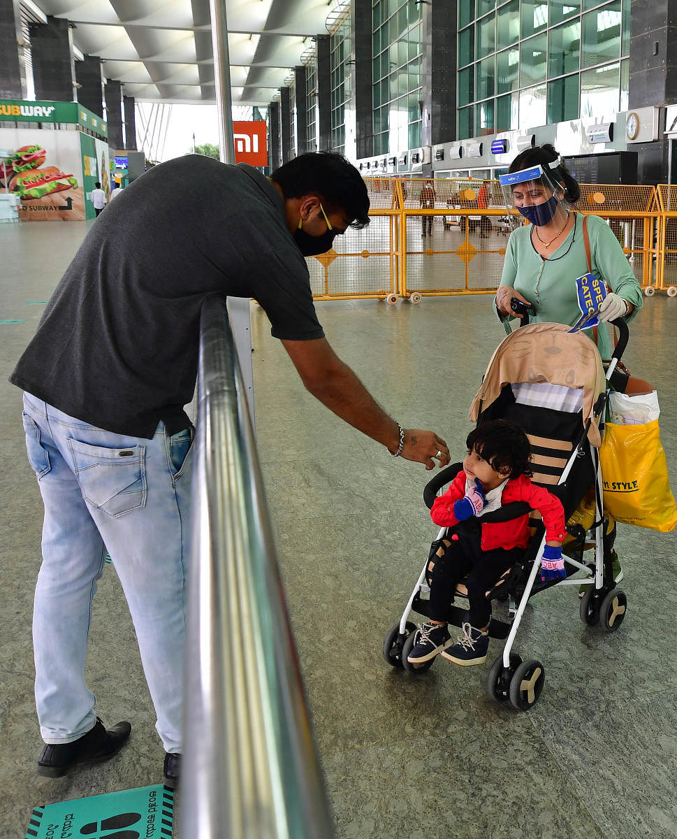 A man talks to his family who arrived at the airport before they were being sent to institutional quarantine. DH photo/Krishnakumar P S