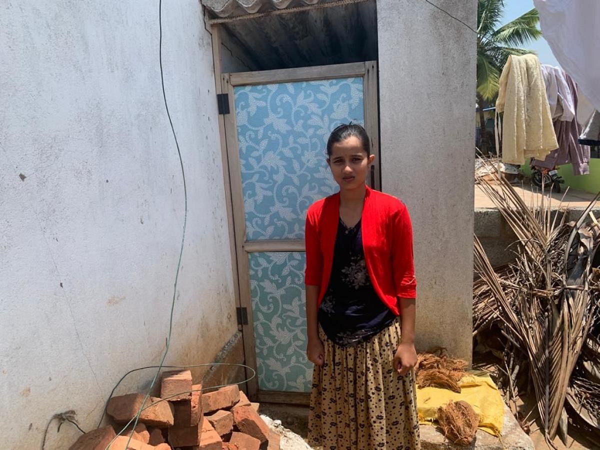 Sinchana next to the newly-built toilet at her home 