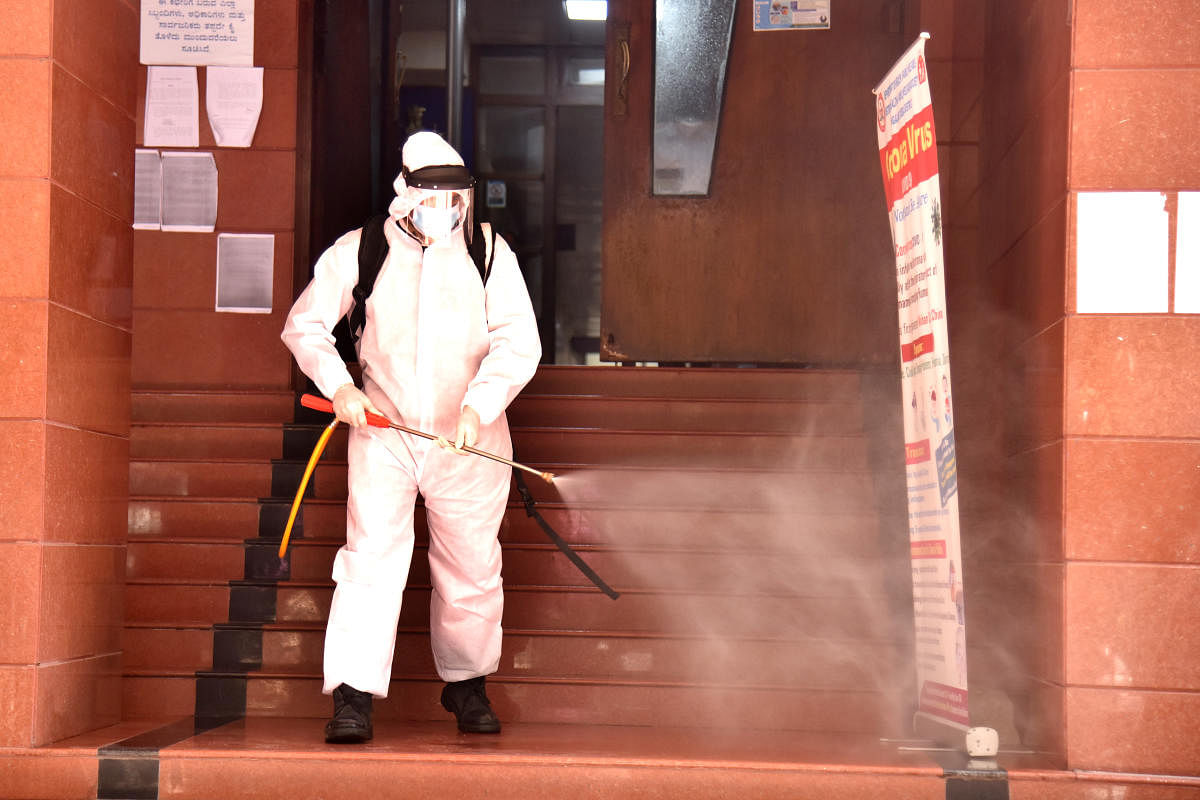 A worker fumigates the Lokayukta's officer after a constable tested positive. DH PHOTO/S K DINESH