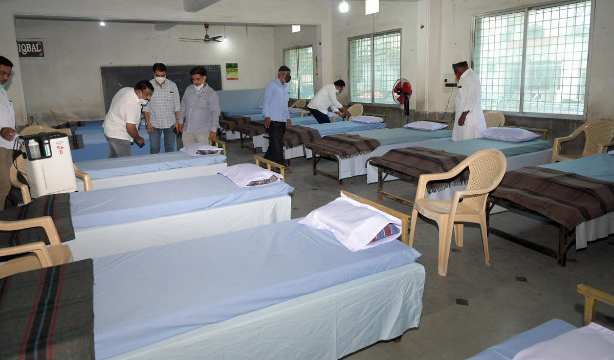 Health department staff arrange beds at a Covid care centre in Mysuru. Credit: DH Photo