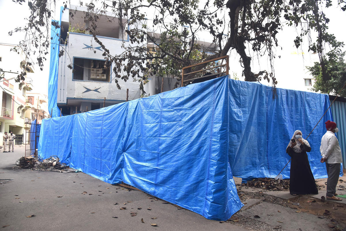 MLA, R Akhanda Srinivas Murthy's house, burnt by a violent mob on August 11, had been sealed and covered in tarpaulin. DH PHOTO/S K DINESH