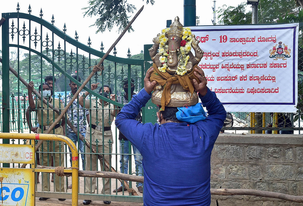 A man brings a Ganesha idol to Halasuru Lake, Bengaluru, unaware of a ban on immersions in the waterbody, on Sunday. DH PHOTO/RANJU P