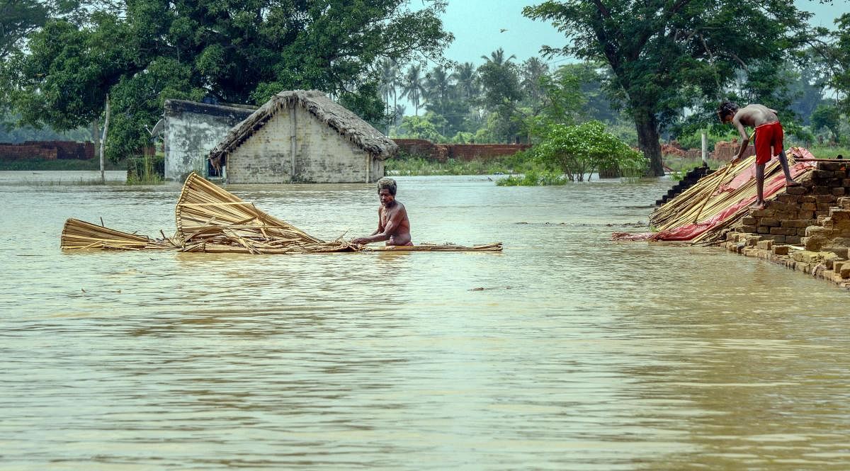 Residents shift from a flooded village near the banks of River Bhargavi in Khordha district of Odisha. PTI 