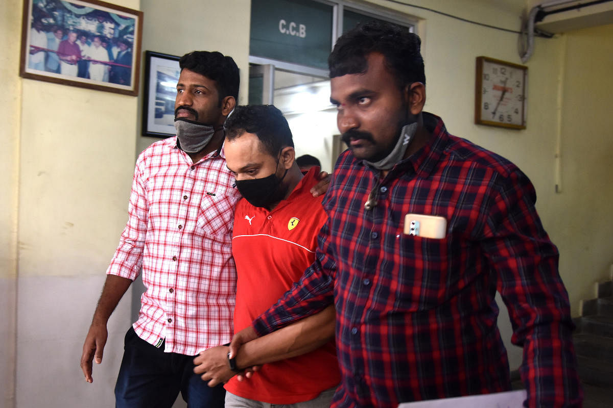 Pratheek Shetty (centre), a suspected high-profile drug peddler, being escorted by Bengaluru police on Friday. DH PHOTO/S K DINESH