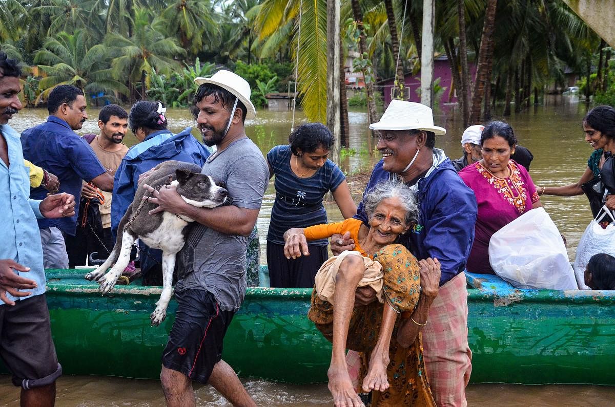 Locals along with NDRF personnel rescue villagers from Udupi and Dakshina Kannada and move them to safer places after heavy rain, in Mangaluru. Sunday, Sept. 20, 2020. PTI Photo